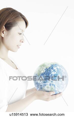 Stock Image - Young Woman Holding The Earth. Fotosearch