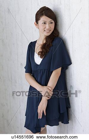 Stock Photograph - Young woman leaning on wall. Fotosearch