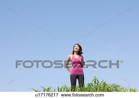 Young woman looking at sky View Large Photo Image Stock Photo - Young woman looking at sky. Fotosearch