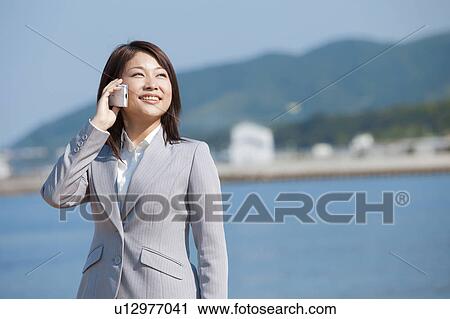 Stock Image - Young woman on cell phone. Fotosearch