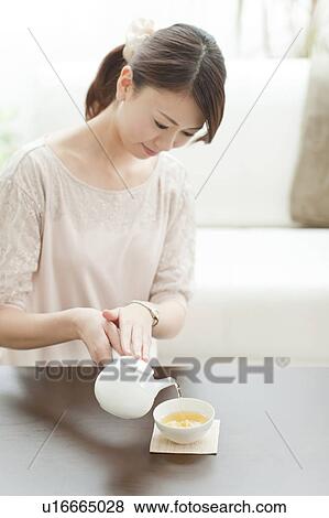 Stock Photo - Young Woman Pouring Tea. Fotosearch