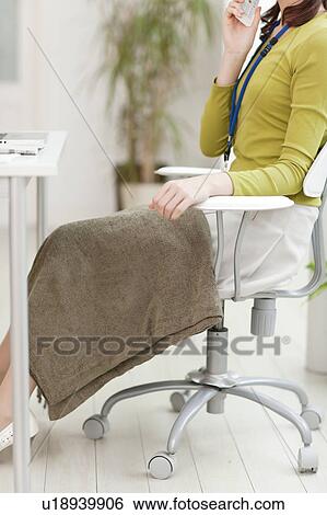 Stock Photograph - Young Woman Sitting at Desk. Fotosearch