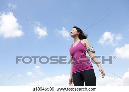 Young woman standing with eyes closed View Large Photo Image Stock Image - Young woman standing with eyes closed. Fotosearch