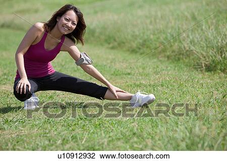 Stock Image - Young woman stretching. Fotosearch
