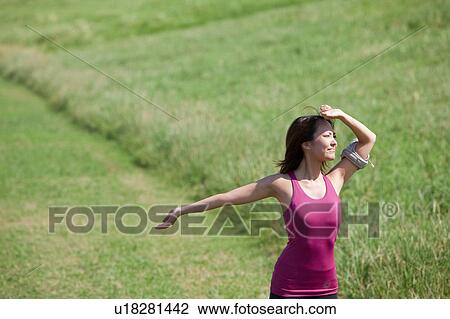 Stock Image - Young woman stretching. Fotosearch