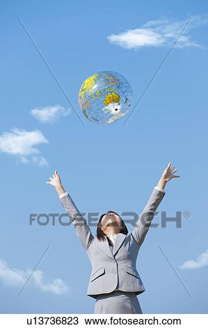 Young woman throwing inflatable globe in the air View Large Photo Image Stock Image - Young woman throwing inflatable globe in the air. Fotosearch