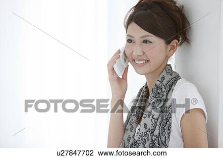 Young woman using a cell phone View Large Photo Image Stock Image - Young woman using a cell phone. Fotosearch