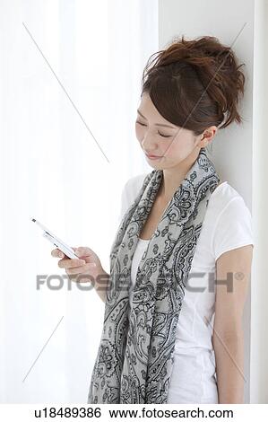 Young woman using a cell phone View Large Photo Image Stock Photograph - Young woman using a cell phone. Fotosearch