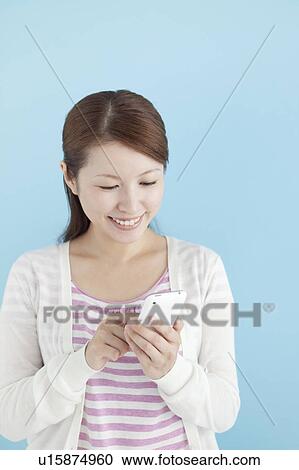 Stock Image - Young Woman Using Mobile Phone. Fotosearch