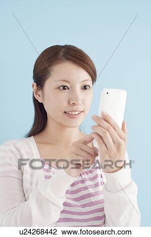 Stock Image - Young Woman Using Mobile Phone. Fotosearch