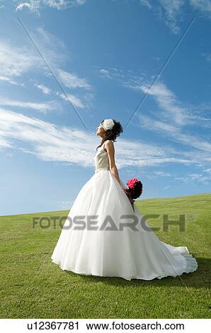 Stock Image - Young woman wearing a wedding dress. Fotosearch