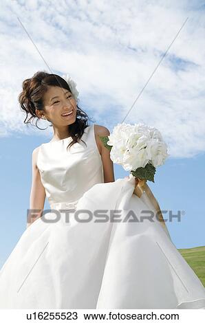 Stock Image - Young woman wearing a wedding dress. Fotosearch