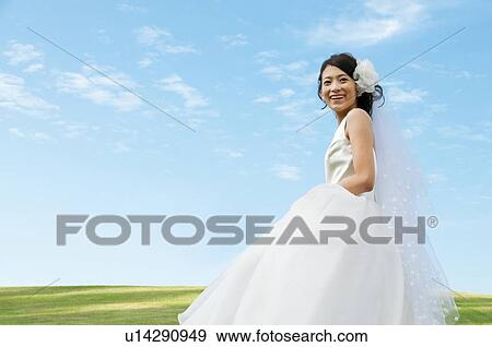 Stock Photo - Young woman wearing a wedding dress. Fotosearch