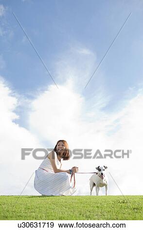 Stock Photo - Young woman with a dog outdoors. Fotosearch