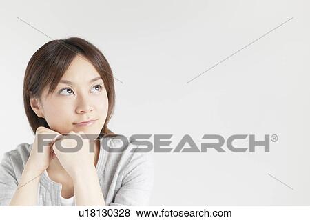 Stock Photo - Young woman with hand on chin. Fotosearch