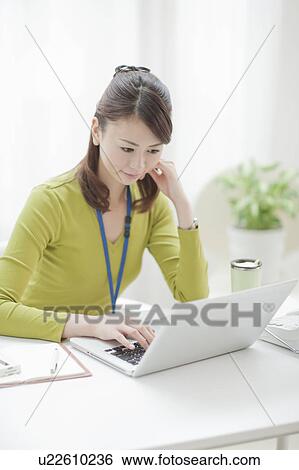 Stock Photograph - Young Woman Working at Desk. Fotosearch