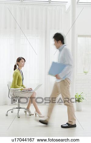 Young Woman Working on Chair, Man Walking Past View Large Photo Image Stock Photo - Young Woman Working on Chair, Man Walking Past. Fotosearch