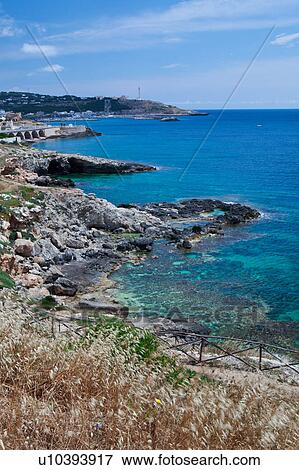 Coastline on sunny afternoon with blue sky, rocky cliffs and beach, calm sea; lighthouse and Basilica of Santa Maria di Leuca, Salento, Puglia, Southern Italy, View Large Photo Image Stock Photo - Coastline on sunny afternoon with blue sky, rocky cliffs and beach, calm sea; lighthouse and Basilica of Santa Maria di Leuca, Salento, Puglia, Southern Italy,. Fotosearch