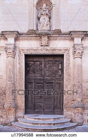 Detail of Romanesque facade of church, with typical stone carved scroll work and statue above decorated doorway, sunny afternoon, Matera, Puglia, Southern Italy View Large Photo Image Stock Photo - Detail of Romanesque facade of church, with typical stone carved scroll work and statue above decorated doorway, sunny afternoon, Matera, Puglia, Southern Italy. Fotosearch
