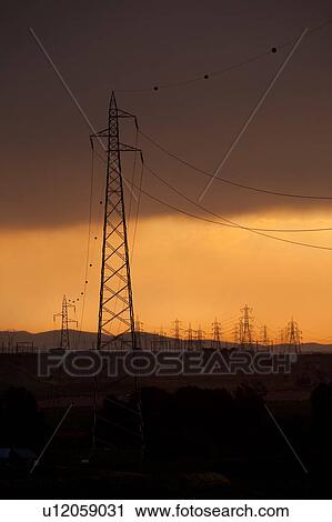 Electric power pylons silhouettted against dramatic storm sky at sunset, Tuscany, Italy View Large Photo Image Stock Image - Electric power pylons silhouettted against dramatic storm sky at sunset, Tuscany, Italy. Fotosearch