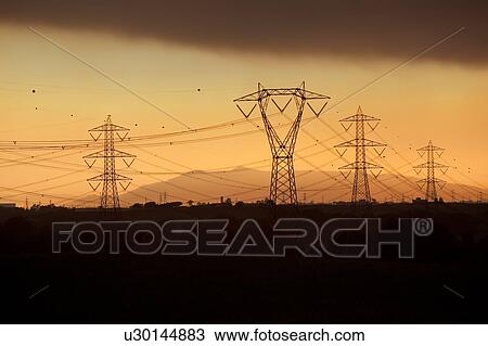 Electric power pylons silhouettted against dramatic storm sky at sunset, Tuscany, Italy View Large Photo Image Stock Image - Electric power pylons silhouettted against dramatic storm sky at sunset, Tuscany, Italy. Fotosearch
