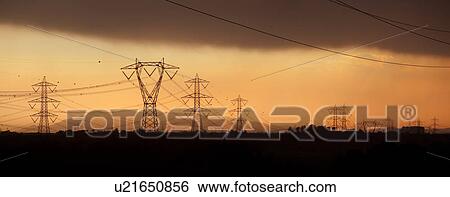 Electric power pylons silhouettted against dramatic storm sky at sunset, Tuscany, Italy View Large Photo Image Stock Photograph - Electric power pylons silhouettted against dramatic storm sky at sunset, Tuscany, Italy. Fotosearch