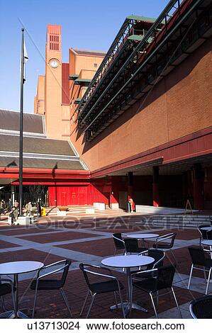Exterior view of British Library, London, England, showing red brick courtyard, and corner detail of layered red brick building, with clock tower, on sunny day with blue sky View Large Photo Image Picture - Exterior view of British Library, London, England, showing red brick courtyard, and corner detail of layered red brick building, with clock tower, on sunny day with blue sky. Fotosearch