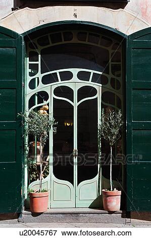 Green Art Nouveau style shop doorway, flanked by potted olive trees, sunny spring morning, Galatina, Salento, Puglia, Southern Italy View Large Photo Image Stock Photo - Green Art Nouveau style shop doorway, flanked by potted olive trees, sunny spring morning, Galatina, Salento, Puglia, Southern Italy. Fotosearch