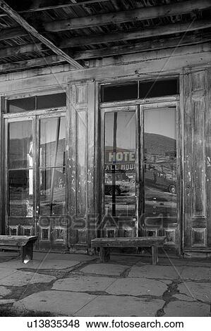 Main hotel doorway with glass abstract reflection of wooden housing, hills and sky in early summer morning, Bodie pioneer village, California View Large Photo Image Stock Photo - Main hotel doorway with glass abstract reflection of wooden housing, hills and sky in early summer morning, Bodie pioneer village, California. Fotosearch