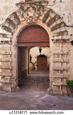 Medieval arched stone entrance, with massive decoration, leading to palazzo courtyard and wooden doorway beyond, sunny morning, Galatina, Salento, Puglia, Southern Italy View Large Photo Image Stock Image - Medieval arched stone entrance, with massive decoration, leading to palazzo courtyard and wooden doorway beyond, sunny morning, Galatina, Salento, Puglia, Southern Italy. Fotosearch