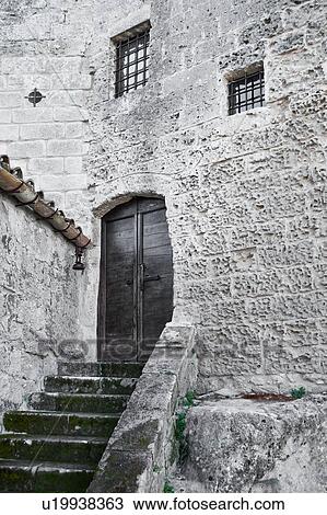 Monochrome view of ancient wooden doorway with stairway, and windows set into stone walls of tufa houses (Sassi), Matera, Puglia, Southern Italy View Large Photo Image Stock Image - Monochrome view of ancient wooden doorway with stairway, and windows set into stone walls of tufa houses (Sassi), Matera, Puglia, Southern Italy. Fotosearch