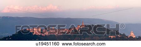 Stock Image - Panorama view of medieval hilltop town of Todi, at sunset, with spire of San Fortunato, and Tempio of Bramante, Umbria, Italy. Fotosearch