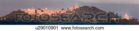 Stock Image - Panorama view of medieval hilltop town of Todi, at sunset, with spire of San Fortunato, and Tempio of Bramante, Umbria, Italy. Fotosearch