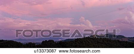 Panorama view of medieval hilltop town of Todi at sunset, ruined castle tower on tree covered ridge in foreground, distant mountains beyond, with spectacular pink clouds, skyscape, Umbria, Italy View Large Photo Image Stock Photo - Panorama view of medieval hilltop town of Todi at sunset, ruined castle tower on tree covered ridge in foreground, distant mountains beyond, with spectacular pink clouds, skyscape, Umbria, Italy. Fotosearch