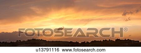 Panoranic view over Ripalvella, village silhouetted at sunset with spectacular cloud formation, orange-gray lighting over sky View Large Photo Image Stock Photograph - Panoranic view over Ripalvella, village silhouetted at sunset with spectacular cloud formation, orange-gray lighting over sky. Fotosearch