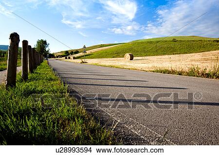 Rural asphalt road with wooden fence on sunny day, Italy springtime View Large Photo Image Picture - Rural asphalt road with wooden fence on sunny day, Italy springtime. Fotosearch