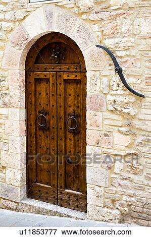 View of old double wooden arched door of stone medieval palace, with traditional iron tie-rod beside, Assisi, Umbria, Italy View Large Photo Image Stock Photo - View of old double wooden arched door of stone medieval palace, with traditional iron tie-rod beside, Assisi, Umbria, Italy. Fotosearch