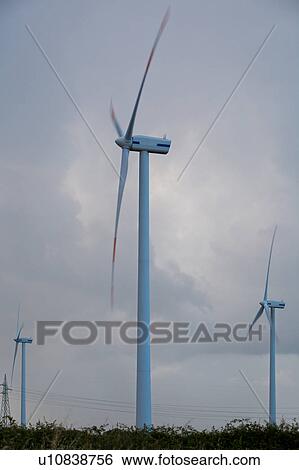 Wind turbines and electricity pylons against stormy grey sky at sunset, Salento, Puglia, Southern Italy View Large Photo Image Stock Photograph - Wind turbines and electricity pylons against stormy grey sky at sunset, Salento, Puglia, Southern Italy. Fotosearch
