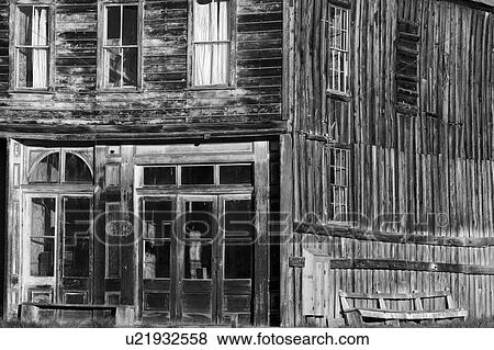 Stock Photo - Wooden buildng, detail of doorway and windows, on main street, lit in dawn light, desaturated image, Bodie pioneer village, California. Fotosearch