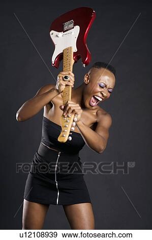 Stock Photo - African American woman about to break guitar. Fotosearch
