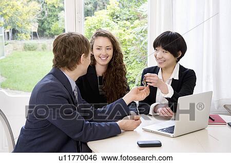 Attractive woman handing over keys to man View Large Photo Image Stock Photograph - Attractive woman handing over keys to man. Fotosearch