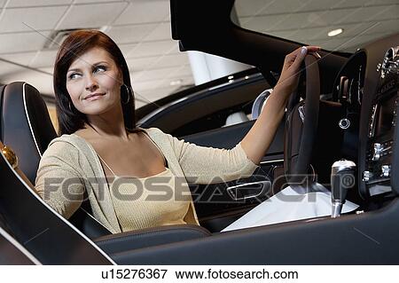 Stock Photo - Attractive woman having a test drive. Fotosearch