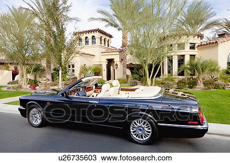 Black convertible car parked in front f luxury house View Large Photo Image Stock Image - Black convertible car parked in front f luxury house. Fotosearch