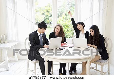 Picture - Businesspeople working on laptop. Fotosearch