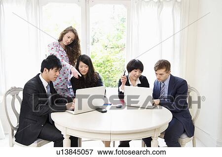 Stock Photo - Businesspeople working on laptop. Fotosearch