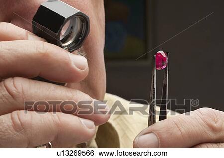 Close up of male jeweler looking at gemstone View Large Photo Image Stock Photograph - Close up of male jeweler looking at gemstone. Fotosearch