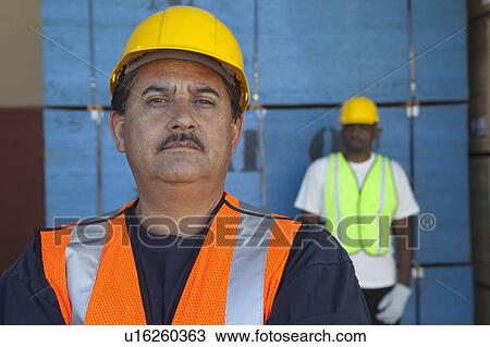 Close-up of middle-aged man with colleague in background View Large Photo Image Stock Image - Close-up of middle-aged man with colleague in background. Fotosearch