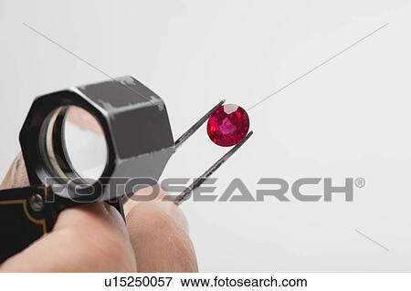 Close up of red gemstone in tweezers View Large Photo Image Stock Photo - Close up of red gemstone in tweezers. Fotosearch