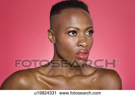 Stock Image - Close up of serious African American woman over colored background. Fotosearch