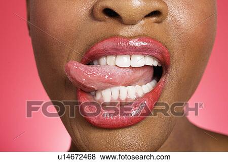 Stock Photo - Close up of woman sticking out tongue. Fotosearch